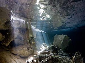 sun rays and surface reflections in Chac Mool Cenote, Mexico by Nick Blake 